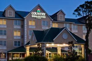 Country Inn & Suites by Radisson, Port Charlotte, FL في بورت شارلوت: تقديم اجنحة فندقية بالفناء