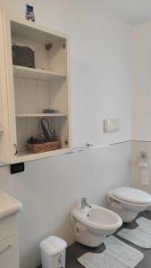 een witte badkamer met een toilet en een wastafel bij Donatella House in Piove di Sacco