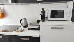 una cucina bianca con forno a microonde e piano di lavoro di Donatella House a Piove di Sacco