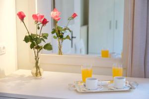 une table avec deux tasses et deux verres de jus d'orange dans l'établissement Prince Studios, à Sami