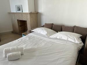 Una cama grande con sábanas blancas y almohadas. en palm Beach studio vue port Canto, en Cannes