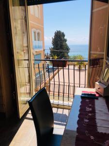 balcón con mesa y vistas al océano en B&B Antonella, en Taormina
