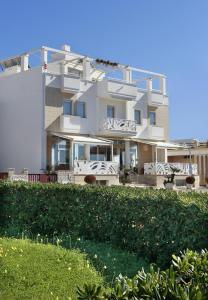 - un grand bâtiment blanc avec des chaises devant dans l'établissement Piccadilly Rooms Restaurant and Beach, à Santa Maria al Bagno