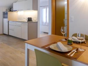 a kitchen with a wooden table with two glasses of wine at Apartment Schwendi 3 by Interhome in Grindelwald