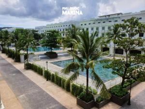 a view of a building with a pool and palm trees at Amara PhuQuoc Hotel in Phú Quốc