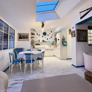 uma cozinha e sala de jantar com mesa e cadeiras em Petite maison de vacance très proches de la mer em Saint Malo