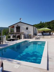 a large swimming pool in front of a house at VILLA ELYSIUM, Slivno - Makarska in Imotski