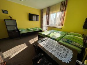 a room with two beds and a tv and a table at Willa Ewa in Jantar