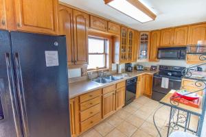 a kitchen with wooden cabinets and a stainless steel refrigerator at Hunter's Haven, 2 Bedrooms, Sleeps 6, Ocean Front, Pet Friendly in Crescent Beach