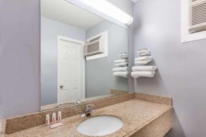 a bathroom with a sink and a mirror at Days Inn by Wyndham Austin/University/Downtown in Austin