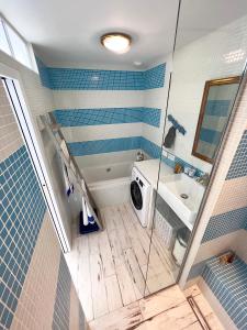 uma casa de banho com um chuveiro e uma máquina de lavar roupa em Petite maison de vacance très proches de la mer em Saint Malo