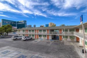 um edifício com carros estacionados num parque de estacionamento em Motel 6-Las Vegas, NV - Tropicana em Las Vegas