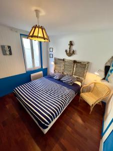 a bedroom with a bed and a lamp and a chair at Petite maison de vacance très proches de la mer in Saint Malo