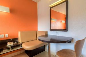a room with a mirror and a table and a chair at Motel 6-Las Vegas, NV - Tropicana in Las Vegas