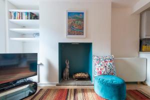 a living room with a blue chair and a fireplace at Hare Cottage in Abergavenny