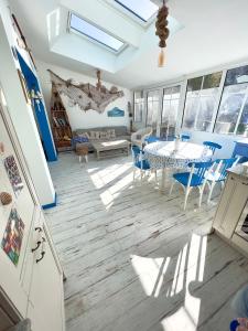 uma sala de estar com uma mesa e cadeiras azuis em Petite maison de vacance très proches de la mer em Saint Malo