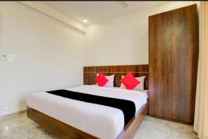 a bedroom with a large white bed with red pillows at Hotel rio inn in Trimbak