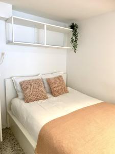 1 dormitorio con cama con almohadas y ventana en Theodore Oostende-zorgeloos genieten in stijl op de perfecte locatie en Ostende