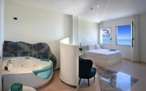 a bathroom with a tub and a bedroom with a bed at Piccadilly Rooms Restaurant and Beach in Santa Maria al Bagno