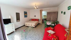 een woonkamer met een rode bank en een tafel bij Studio a Banyuls sur Mer a 300 m de la plage avec terrasse amenagee et wifi in Banyuls-sur-Mer