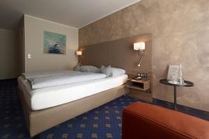 a hotel room with a large bed and a couch at Hotel Garni Arcis in Gomaringen