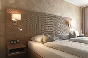 ein Hotelzimmer mit 2 Betten und 2 Lampen in der Unterkunft Hotel Garni Arcis in Gomaringen