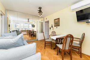 a living room with a couch and a dining room at Apartament Emilii Plater by Your Freedom in Warsaw