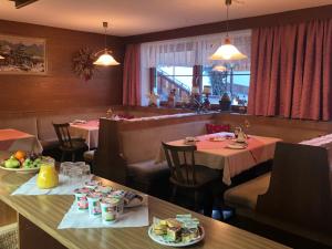un ristorante con due tavoli e sedie con piatti di cibo di Olga Geiger - Bergheimat a Bach