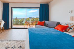 a bedroom with a large bed and a living room at Hotel le Jardin d'Emile in Porticcio