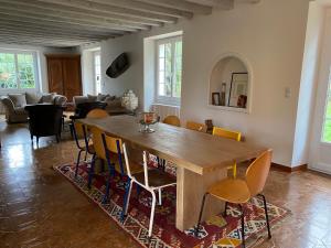 een eetkamer met een houten tafel en stoelen bij Maison de campagne familiale sur la route des Châteaux in Huisseau-sur-Mauves