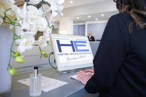 a woman standing at a computer with a hr sign on it at Executive Inn Boutique Hotel in Brindisi