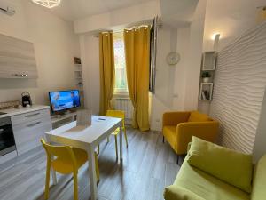 a small living room with a table and yellow chairs at AfforiCentro in Milan
