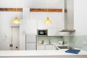 eine Küche mit weißen Schränken und zwei Lampen in der Unterkunft SANTANDER CENTRO in Santander + 9 Fotos