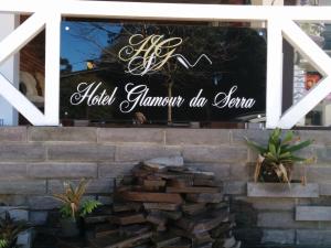 a sign in a window with a pile of bricks at Hotel Glamour da Serra in Gramado