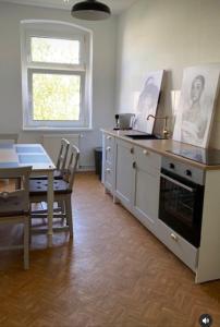 a kitchen with a stove and a table and a window at Gästewohnung Eberswalde in Eberswalde