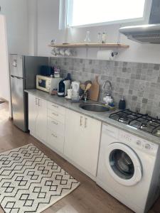a kitchen with a washing machine and a sink at Fressh House in Sîncrăieni +13 photos