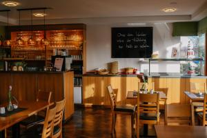 a restaurant with tables and chairs and a bar at Landhotel Dresden in Dresden