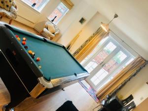 a pool table in a living room next to a window at Castle House in Tyldesley
