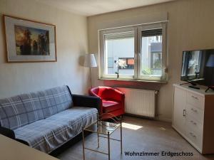 フルダにあるFewo Fulda Neuenbergのリビングルーム(ソファ、赤い椅子付)