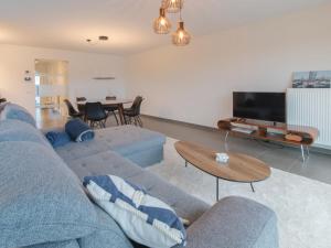 ein Wohnzimmer mit einem blauen Sofa und einem Tisch in der Unterkunft Apartment Ocean by Interhome in Bredene