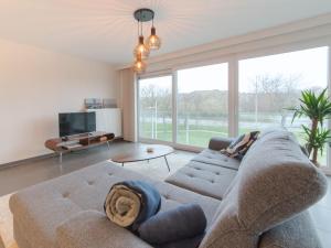 ein Wohnzimmer mit einem Sofa und einem großen Fenster in der Unterkunft Apartment Ocean by Interhome in Bredene