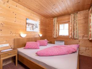 a bedroom with a bed in a wooden cabin at Holiday Home Lindenalm by Interhome in Schwendau