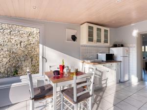 a kitchen with a table and chairs in a room at Holiday Home La peite maison by Interhome in Gouville-sur-Mer