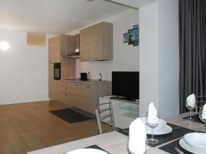 a kitchen and living room with a table and a television at Apartment Charming Gardenview App- 105 by Interhome in Bissone