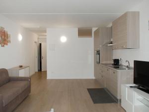 a living room with a couch and a kitchen at Apartment Charming Gardenview App- 105 by Interhome in Bissone +13 photos