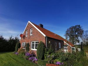 a red brick house with flowers in the yard at Holiday Home Witten by Interhome in Moorweg