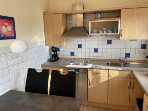 a small kitchen with a sink and a dishwasher at Holiday Home Kiel by Interhome in Norddeich