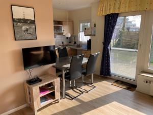 a kitchen and dining room with a table and chairs at Holiday Home Kiel by Interhome in Norddeich