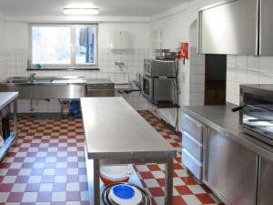 a kitchen with stainless steel appliances and a checkered floor at Holiday Home Hexenstüble by Interhome in Simonswald