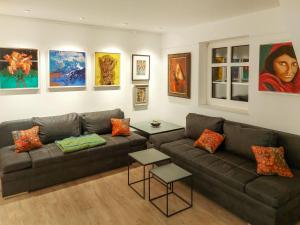 a living room with a couch and paintings on the wall at Holiday Home Grenzenlos by Interhome in Bad Brambach